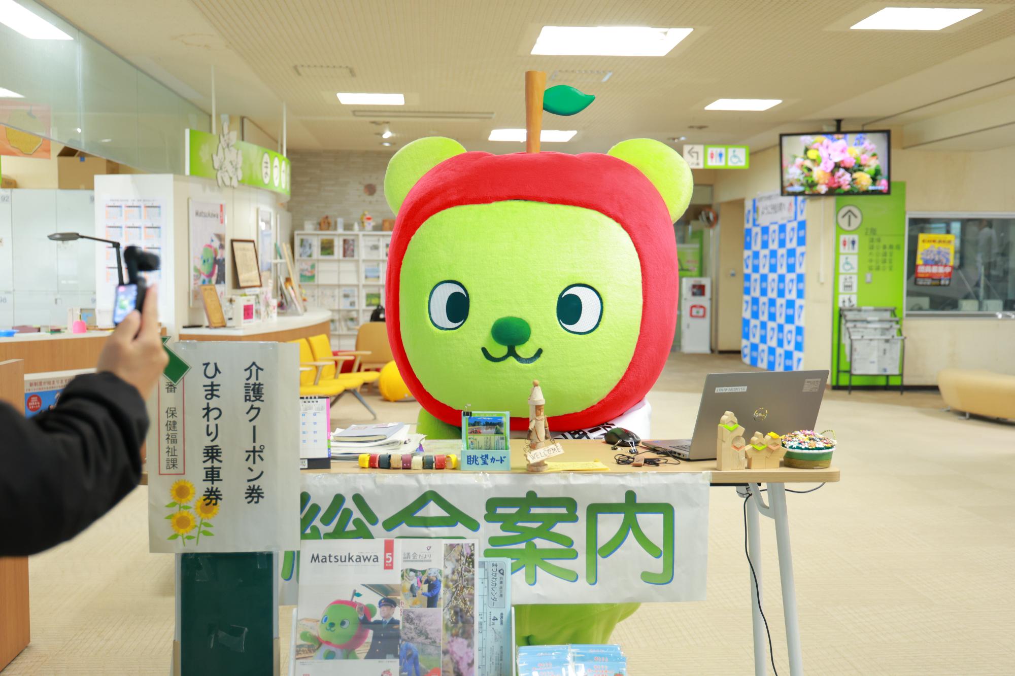 役場の総合案内で接客しようとするアルクマ