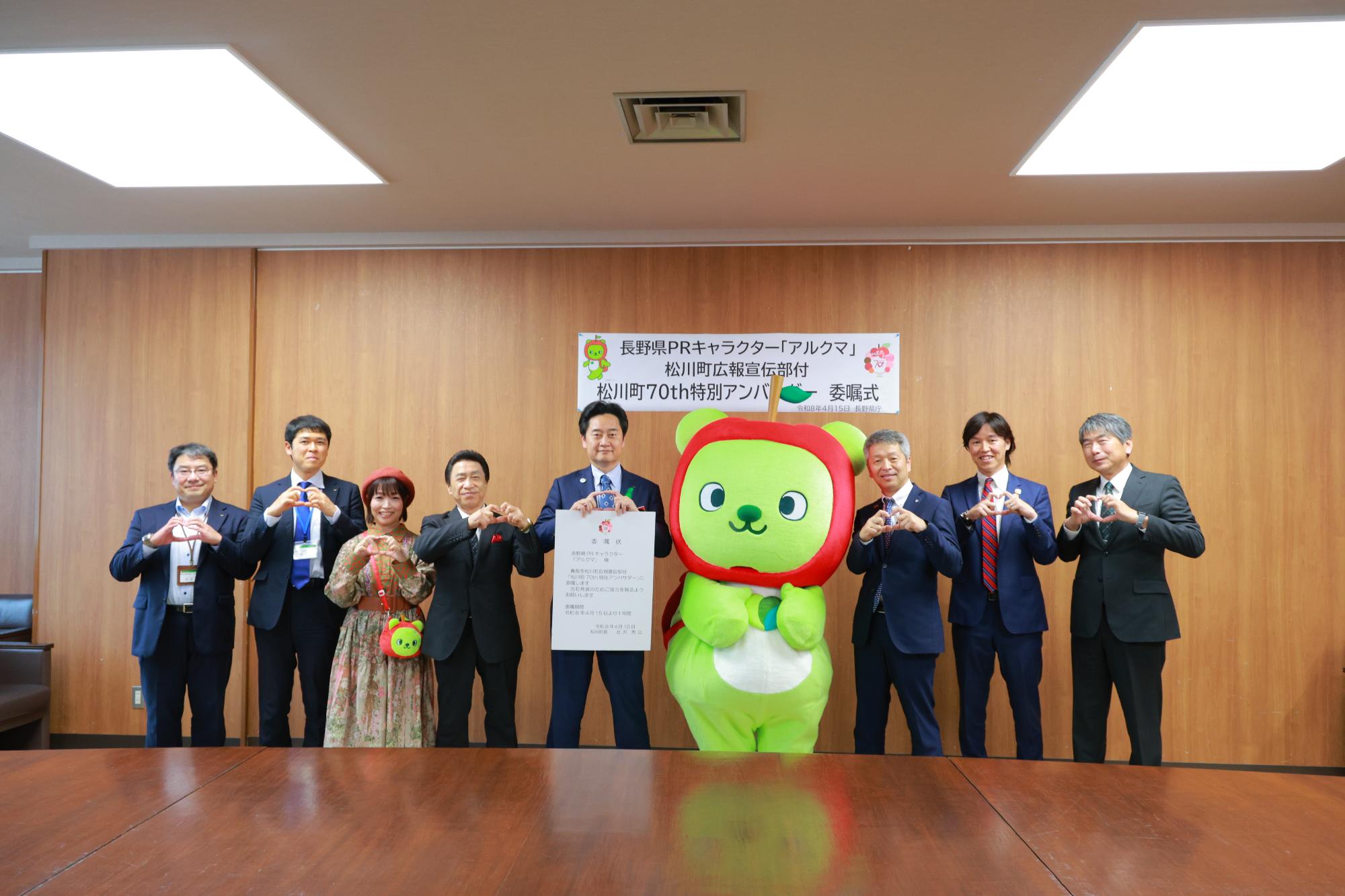 アルクマ委嘱式で広報宣伝部と町長たちがりんごポーズしている写真