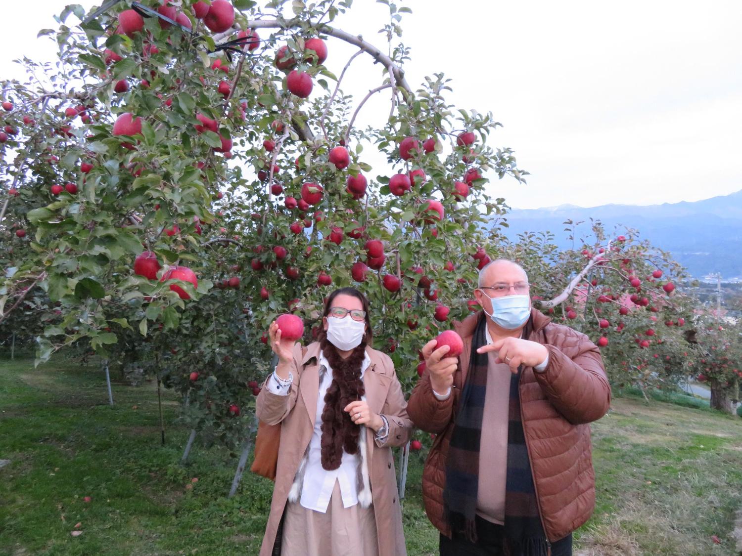 町特産のりんごを手にする大使夫妻